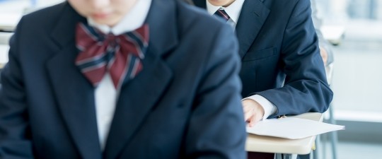 共通テスト模試を受験する高校生・既卒生の様子。マークシート形式の問題に取り組む試験会場のイメージ